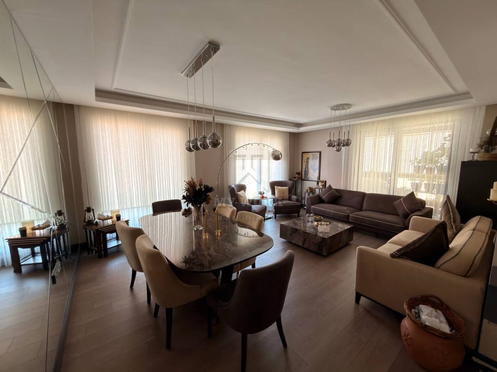 Yemek masası ve oturma grubu bulunan geniş pencereli salon