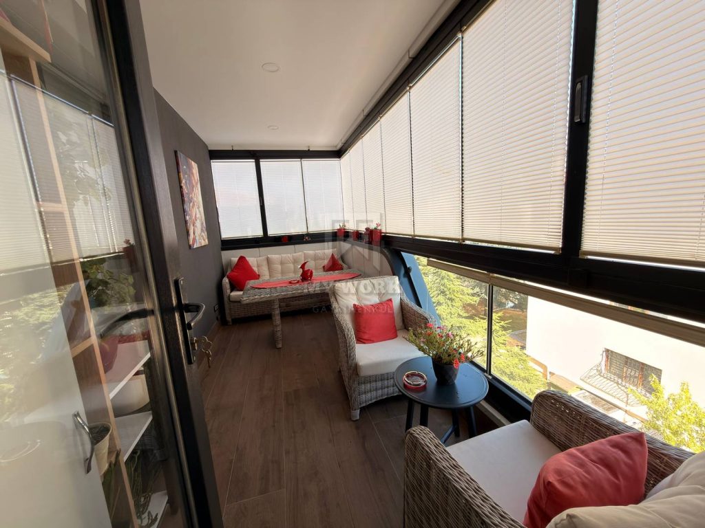 Masa ve minderli oturma alanı bulunan cam balkon