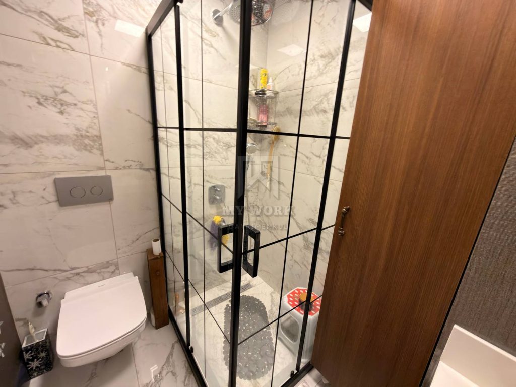 Banyodaki cam duş kabini ve asma klozet